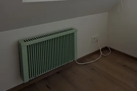 Salbeigrüne Flächenspeicherheizung unter einer Dachschräge